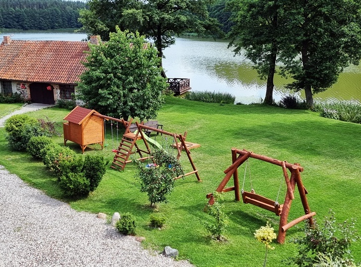 Mazurski Raj - Luksusowa Turystyka [-10% z Kartą] Widok z balkonu na stronę południowo-zachodznią z widokiem na kuźnię i plac zabaw.