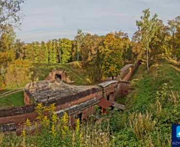 Twierdza Boyen - pawilon - Fragment twierdzy Boyen ukazujący historyczny mur i piękny jesienny krajobraz w tle, popularna atrakcja turystyczna Giżycka.