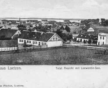 1910, Panorama Giżycka i ulica 1-go Maja - Fotografia z 1910 roku, ukazująca panoramę miasta z ulicą 1-go Maja na pierwszym planie, kluczowym punktem handlowym tamtych czasów.